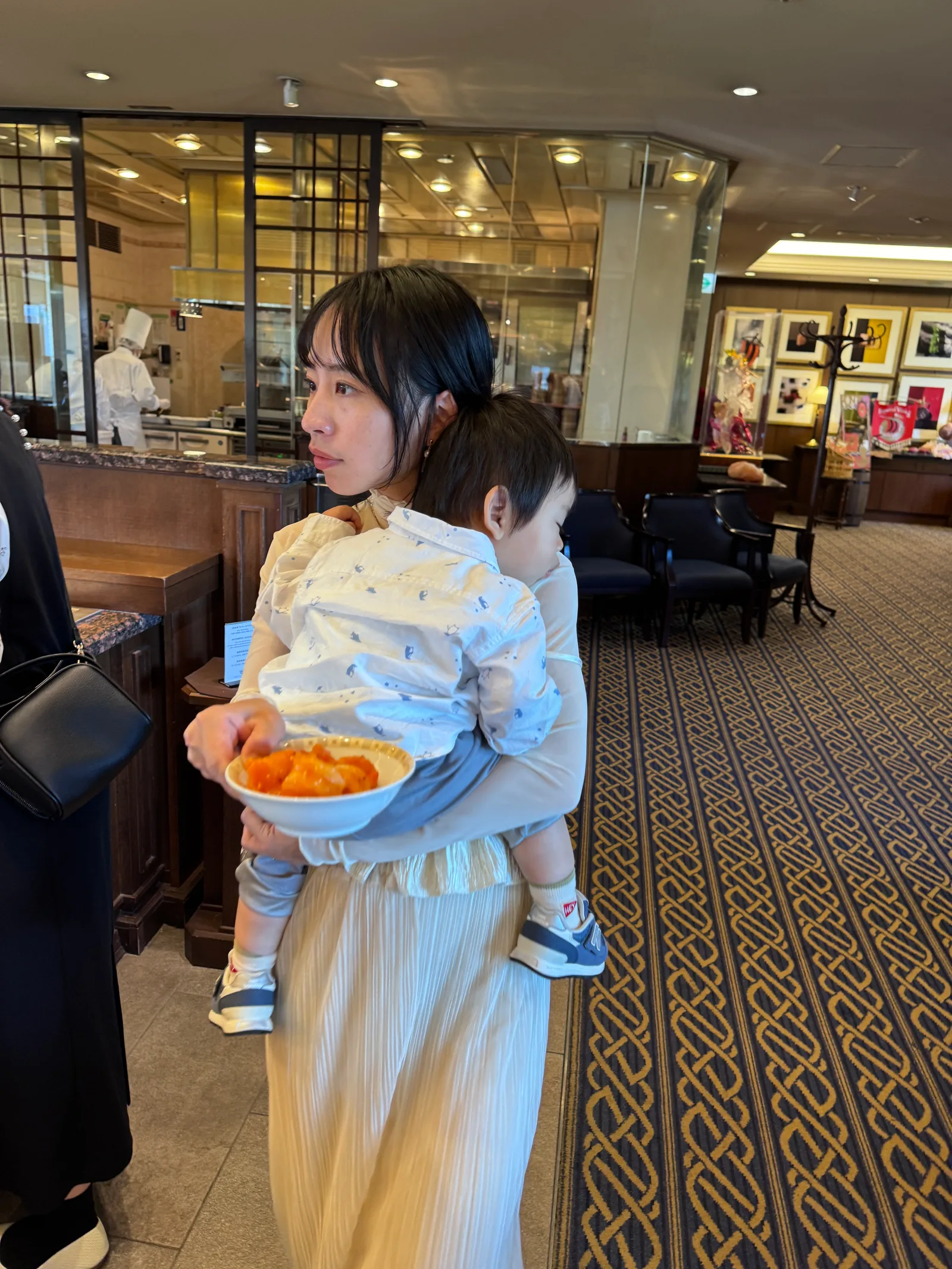 在飯店自助餐廳幫孩子夾菜的媽媽與小孩