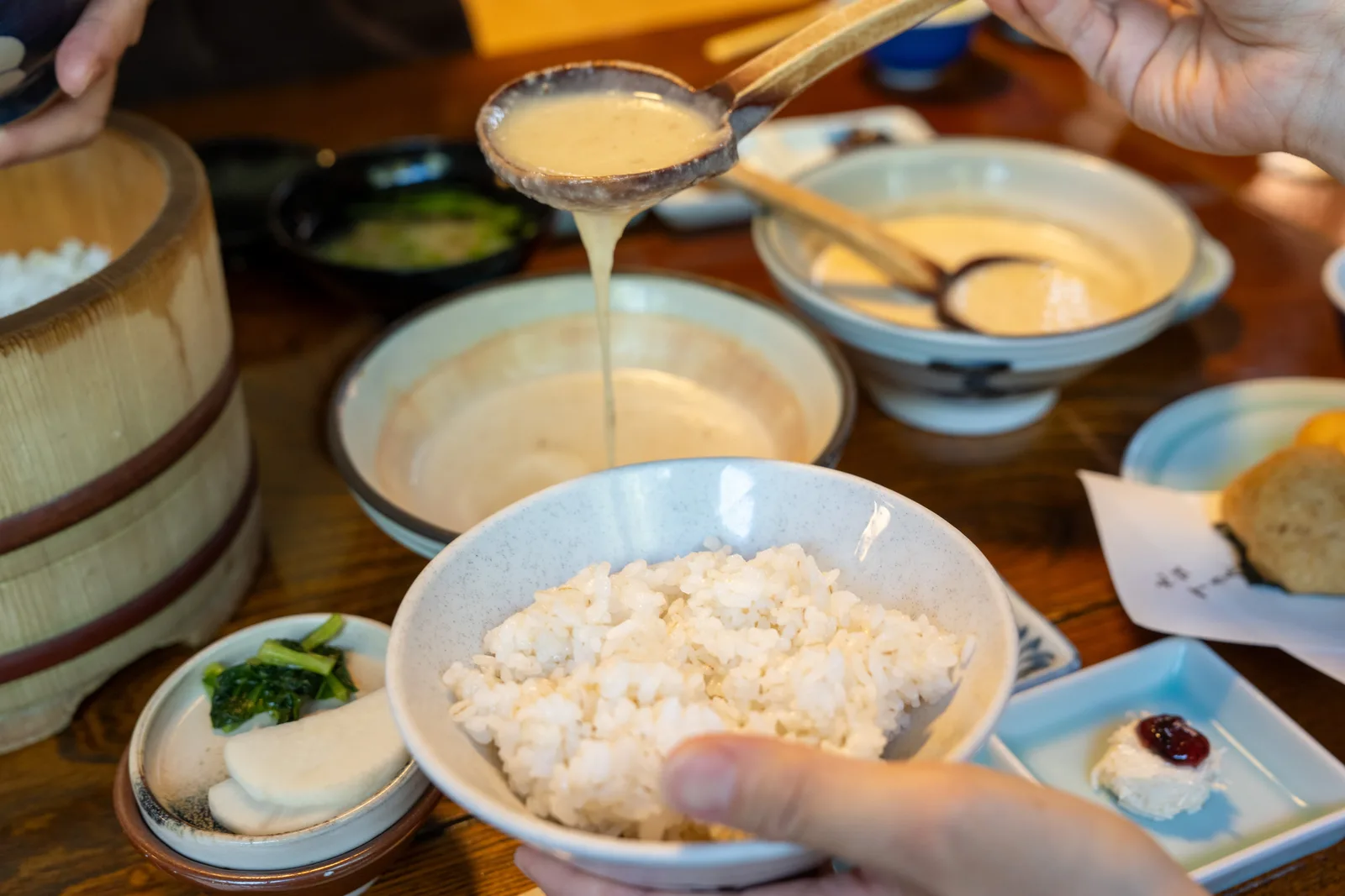 把丁子屋的山藥泥淋在麥飯上的畫面