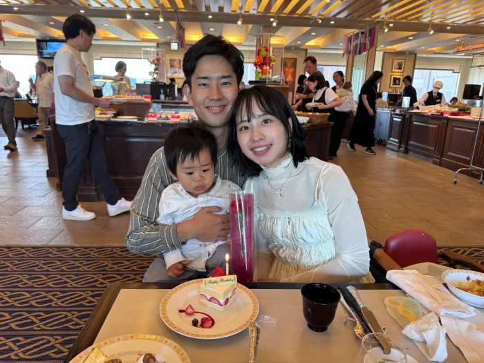 在帝國飯店自助餐廳圍著生日蛋糕的一家人