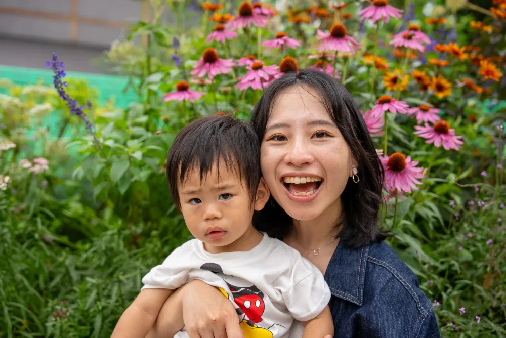 在代代木公園的花圃前笑開懷的媽媽與孩子