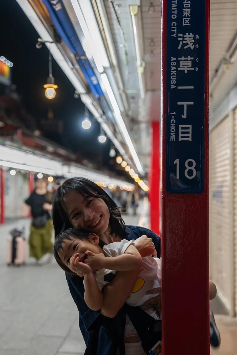 在商店街的路標旁，臉貼著臉