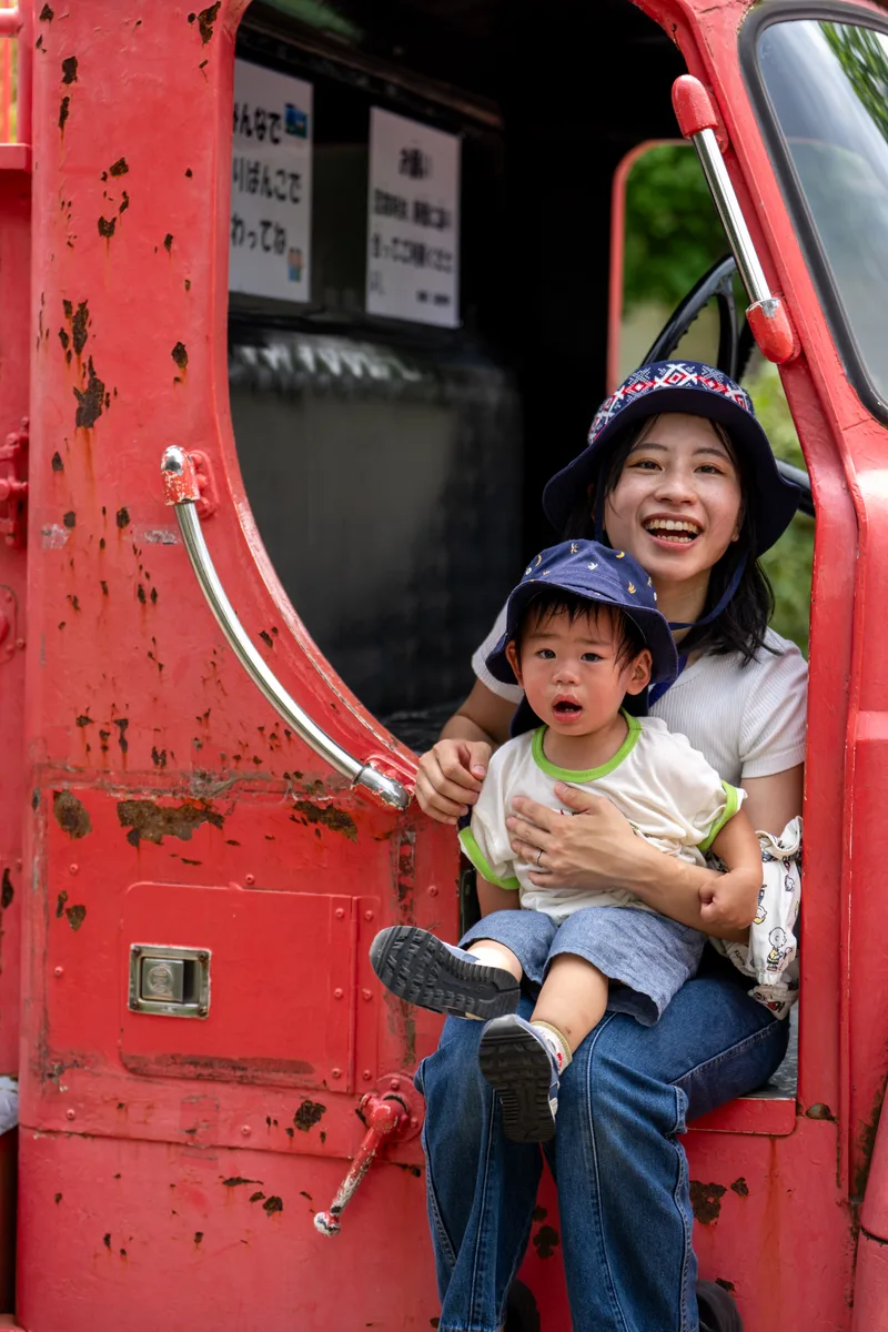 坐在消防車的門邊，笑到停不下來